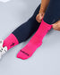 Person wearing pink socks with 'FEARLESS' text on a light gray background