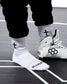 White wrestling shoes and socks with black symbols on a gray surface