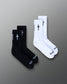 Black and white socks with cross designs on a gradient gray background