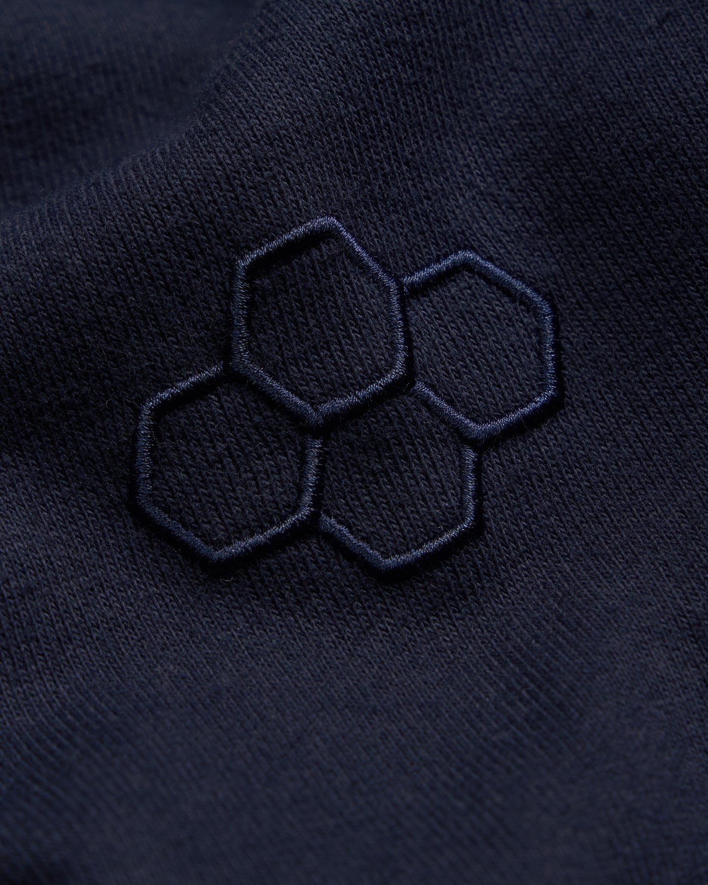 Navy blue fabric with embroidered hexagonal pattern