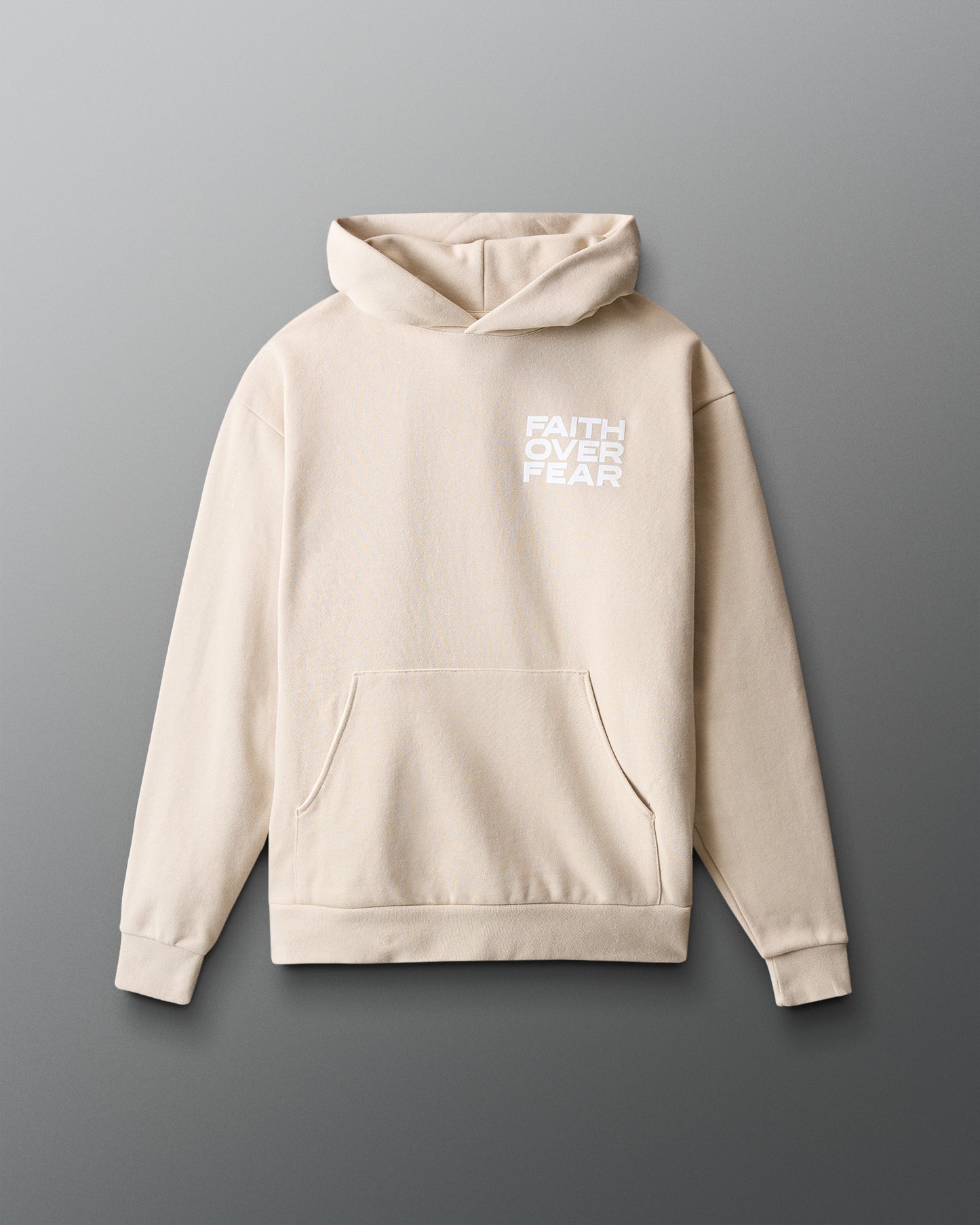 Beige hoodie with 'Faith Over Fear' text on a gray background