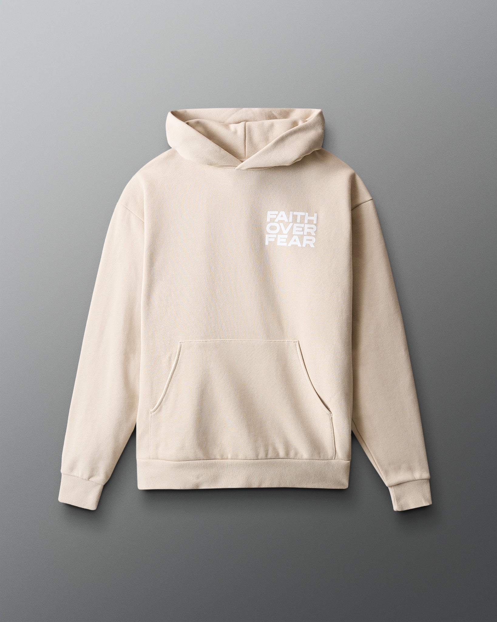 Beige hoodie with 'Faith Over Fear' text on a gray background