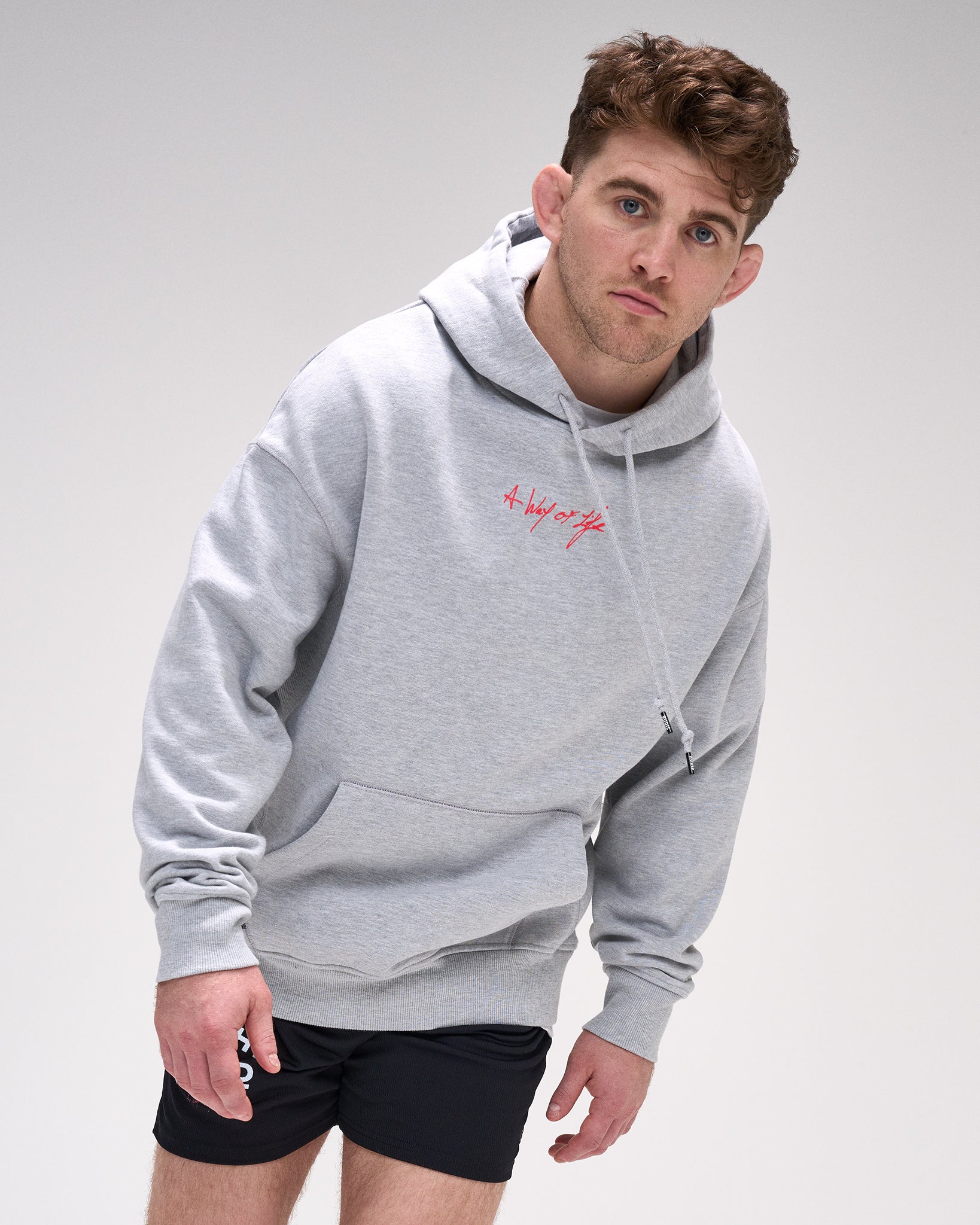 Man wearing a gray hoodie with 'A way of life' text on a plain background