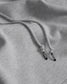 Close-up of gray hoodie with drawstring and 'RUDIS' brand logo on the aglet