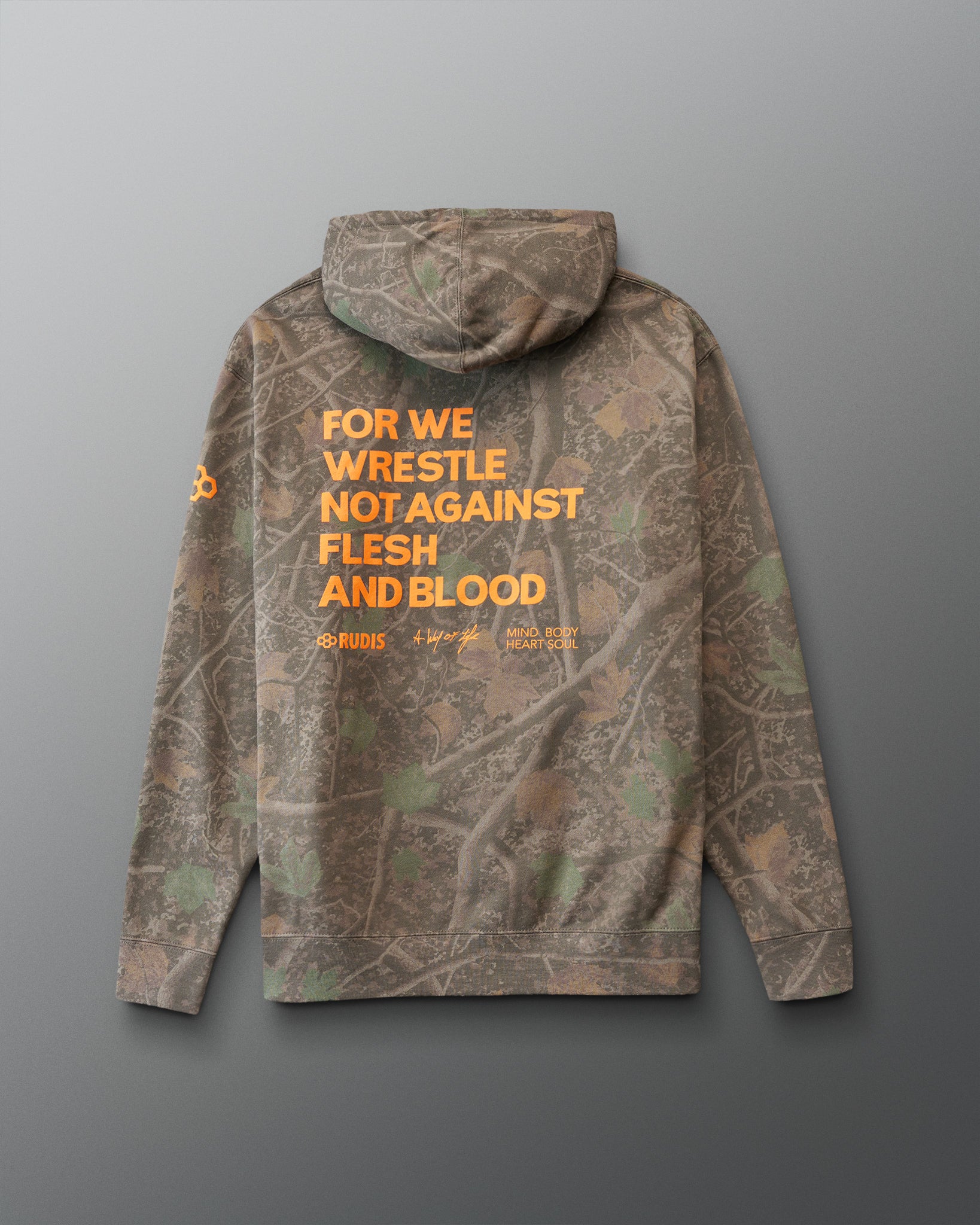 Camouflage hoodie with orange 'For we wrestle not against flesh and blood' text on the back against a gray background