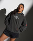 Person wearing a dark gray hoodie with 'Iron sharpens Iron' text and black shorts against a gradient background