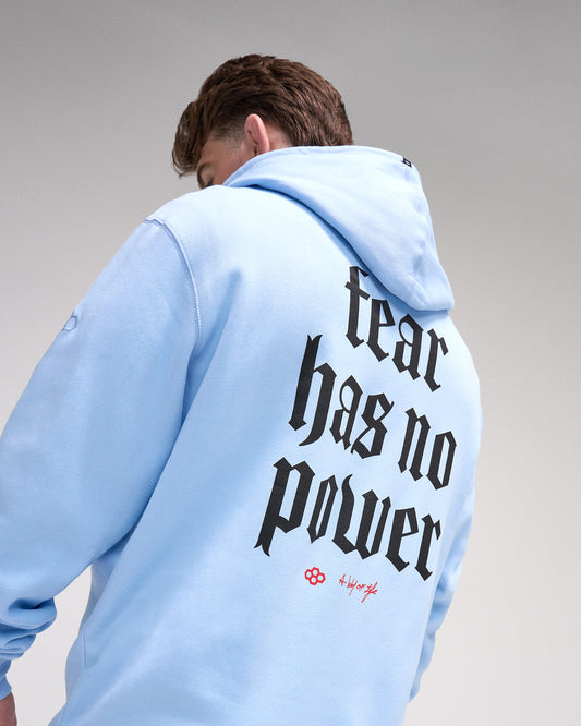 Person wearing a light blue hoodie with 'Fear has no power' text on the back against a gray background