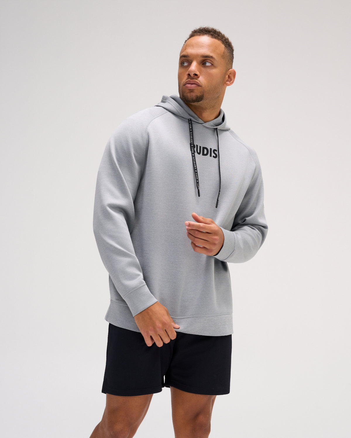 Model wearing the heather gray RUDIS Contrast COOL-FEEL Hoodie with black RUDIS chest branding, branded drawcords, and athletic fit.