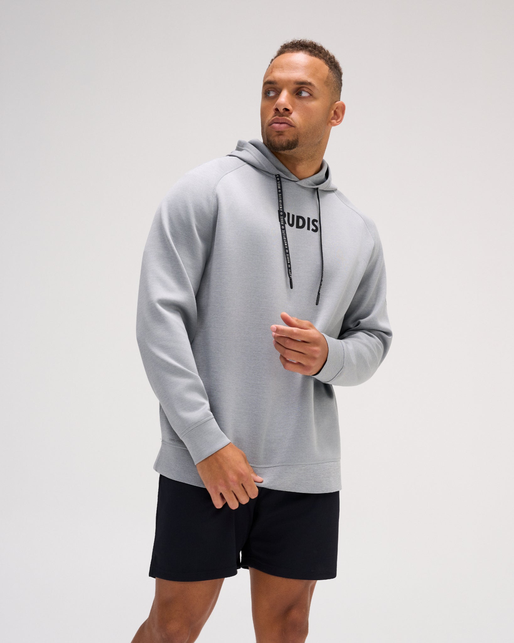 Model wearing the heather gray RUDIS Contrast COOL-FEEL Hoodie with black RUDIS chest branding, branded drawcords, and athletic fit.