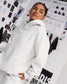 Female model wearing the Heather Silver RUDIS Essential Hex fleece hoodie, showcasing its relaxed fit, tonal chest logo and kangaroo pocket.