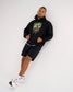 Male model wearing the RUDIS Divine Struggle Relaxed Comfort Fleece Hoodie in Black, showing the wrestling-inspired chest graphic and relaxed silhouette.
