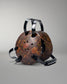 Rustic camo headgear with black handles on a gray background
