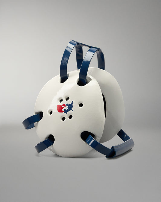 White wrestling headgear with usa wrestling logo with blue straps and a logo on a gray background