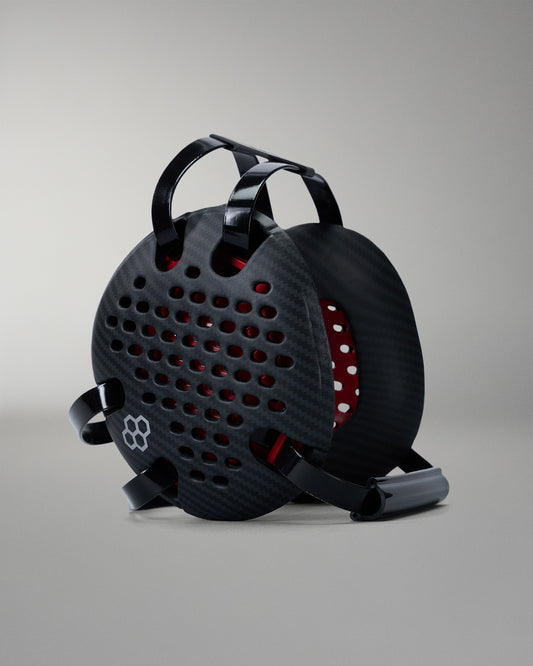 Black wrestling headgear with red interior on a gray background