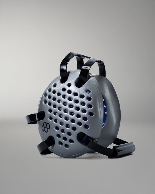 Gray wrestling headgear with black straps on a gray background