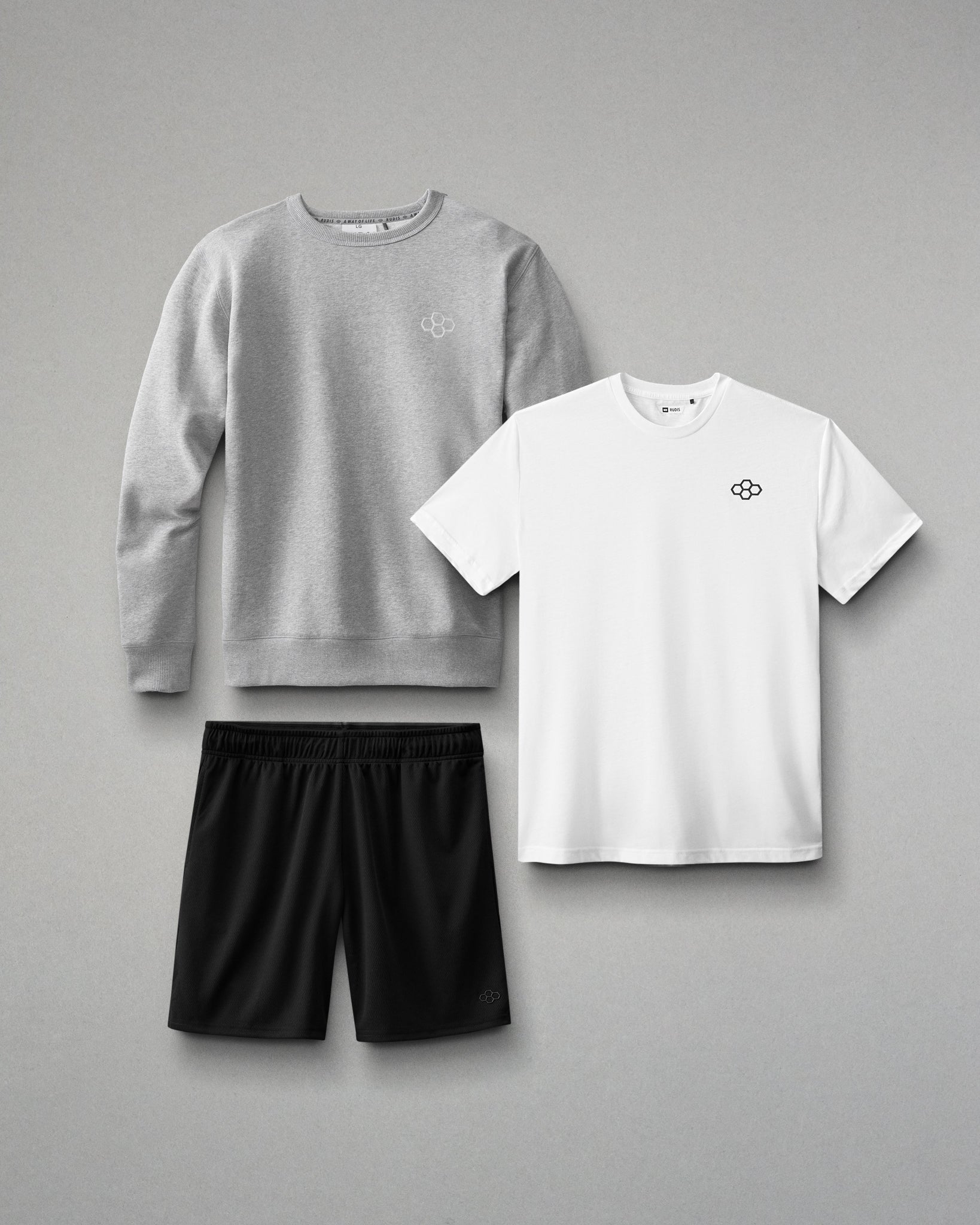 Gray sweatshirt, white t-shirt, and black shorts on a gray background