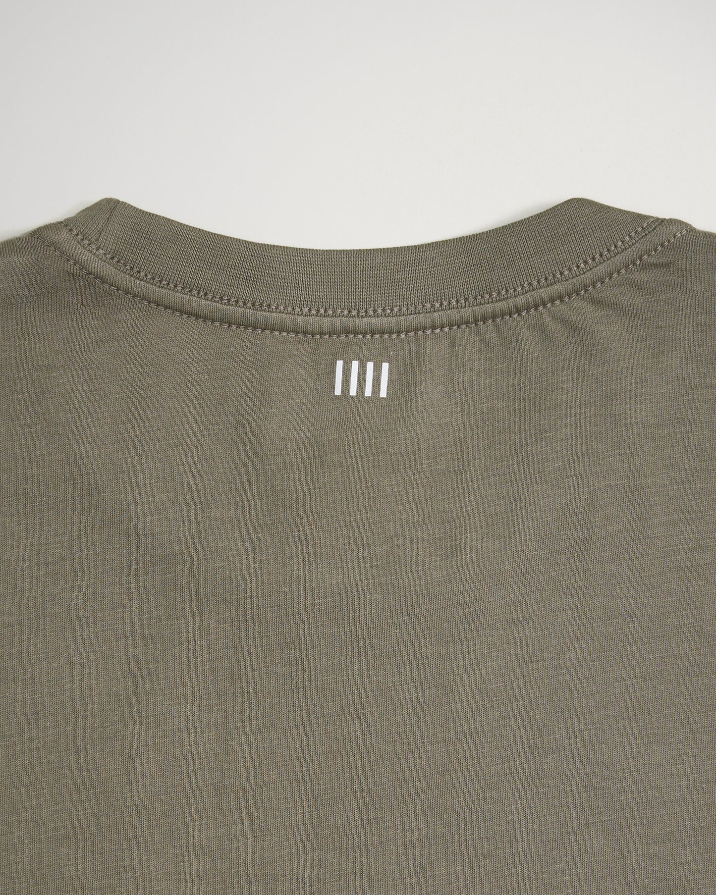 The back of a casual olive green t-shirt featuring a simple white logo printed near the neckline