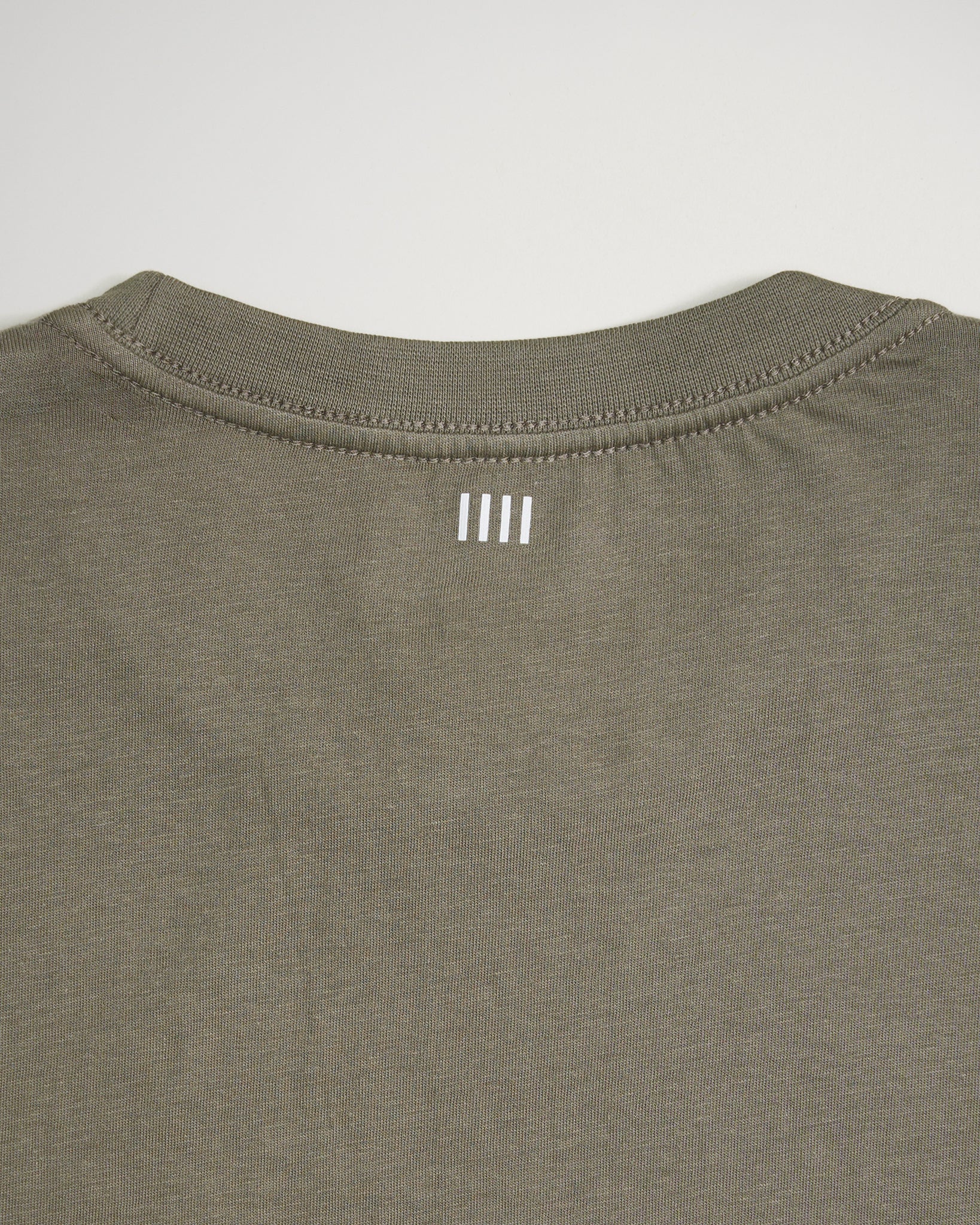 The back of a casual olive green t-shirt featuring a simple white logo printed near the neckline