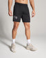 A male model stands confidently in athletic black shorts labeled WRESTLING and neutral-toned shoes showcasing an active lifestyle