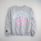 A gray sweatshirt featuring vibrant graphic text and logos associated with wrestling combining style and sporty appeal