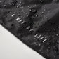 A close-up view of a black fabric with water droplets and the phrase A WAY OF LIFE printed in white