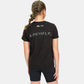 A young girl wearing a black T-shirt with the phrase A WAY OF LIFE printed on the back paired with black shorts showcasing a sporty and casual style