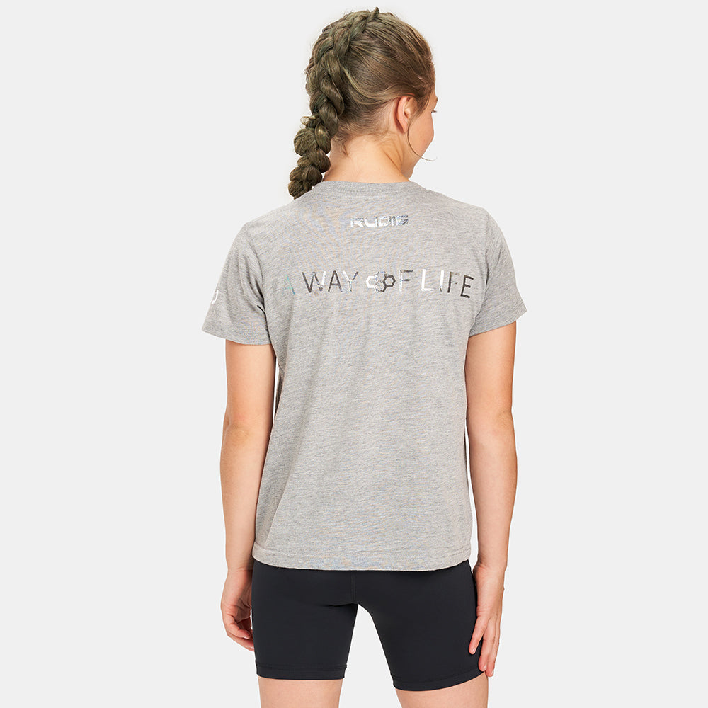 A young girl wearing a gray t-shirt with WAY OF LIFE printed on the back styled with black shorts showcasing an active lifestyle