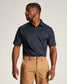 A man in a navy polo shirt and khaki pants poses confidently showcasing a modern casual outfit suitable for various occasions