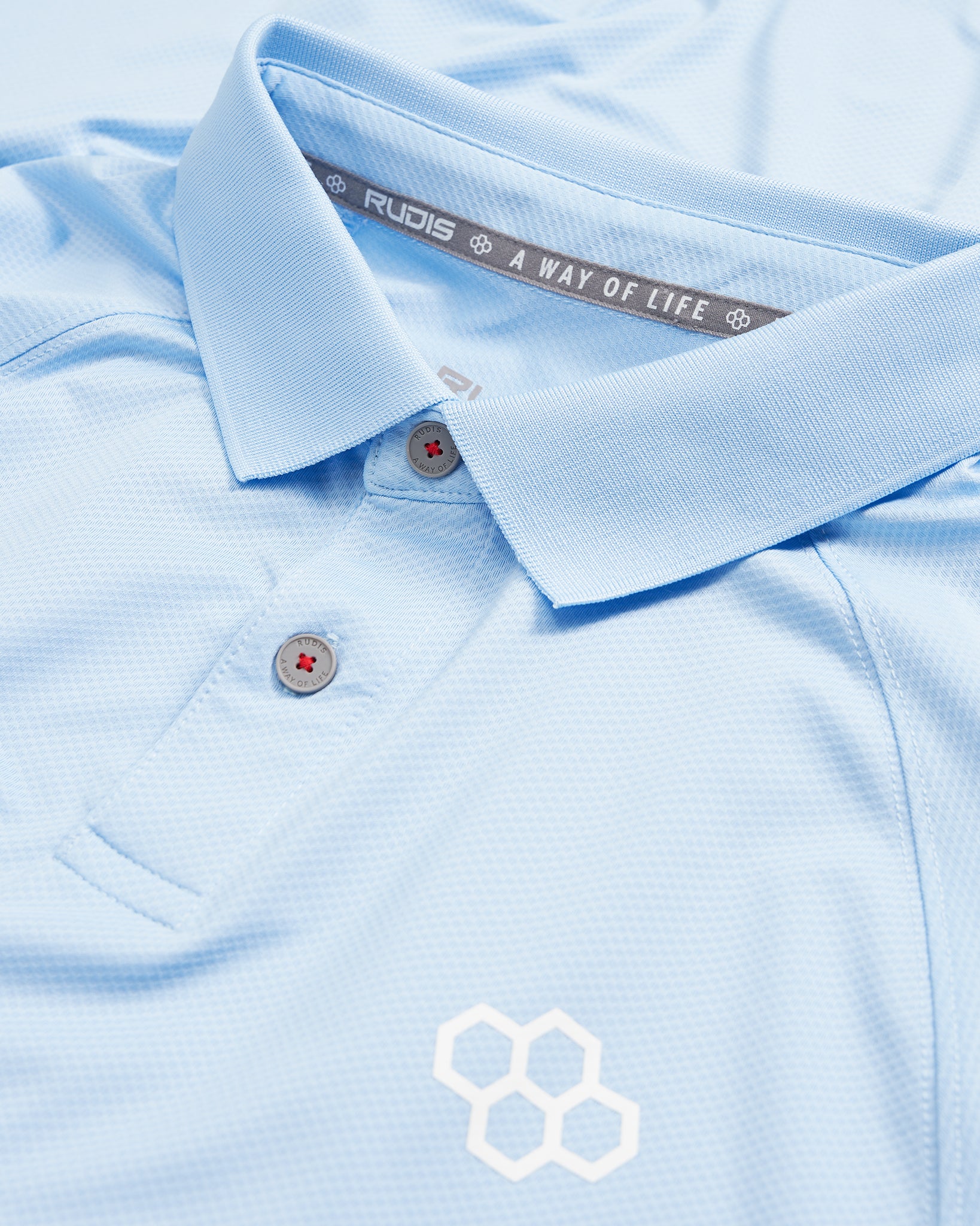 A light blue polo shirt with a woven texture featuring a simple white logo and branded label inside the collar
