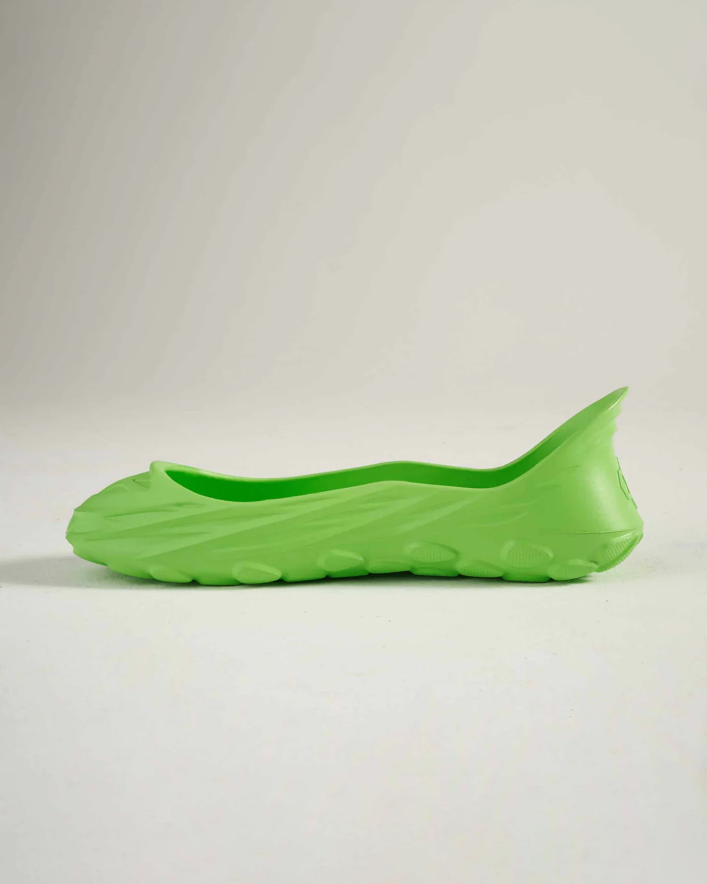 A vibrant green slip-on shoe with a textured sole designed for comfort and casual wear
