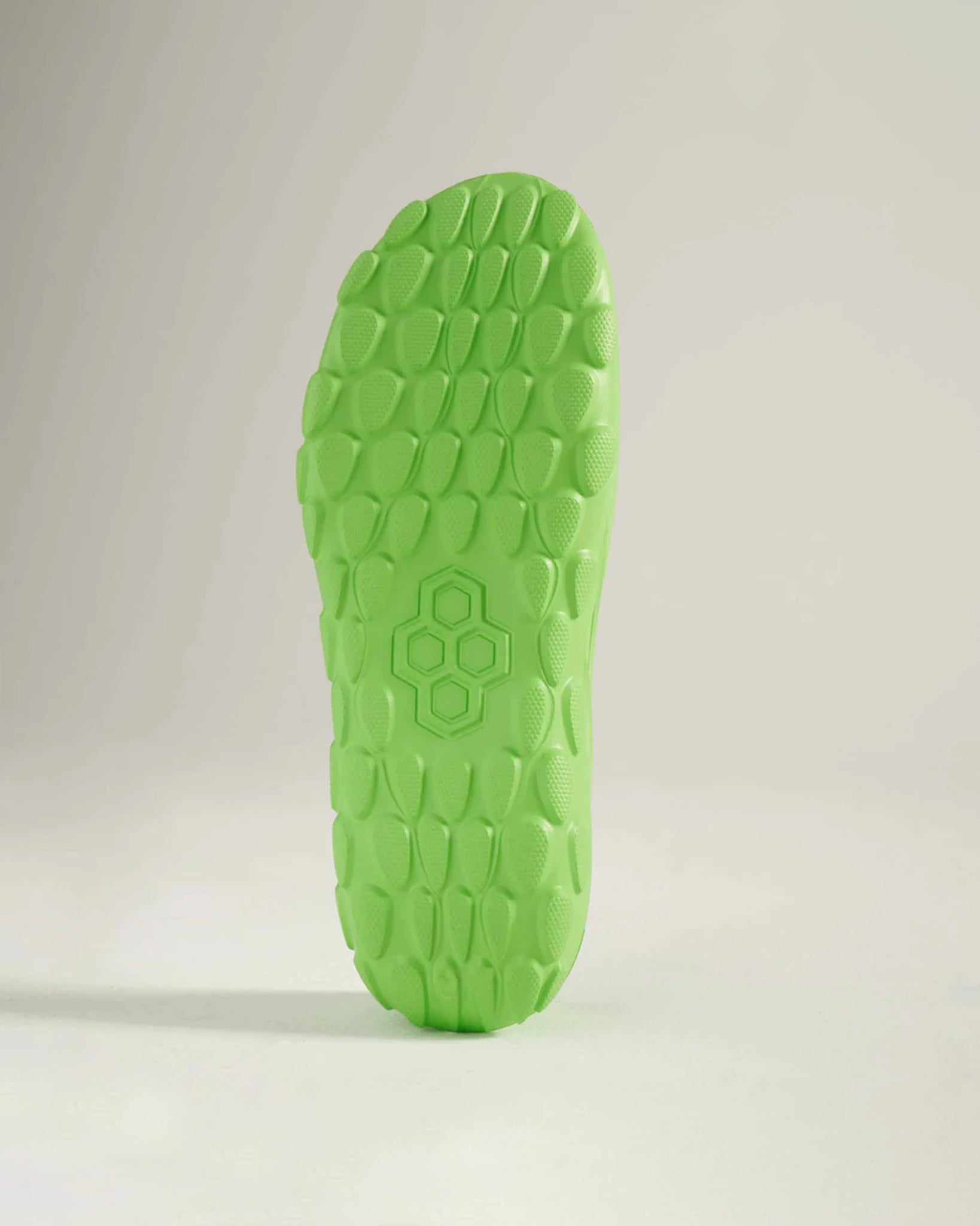 A vibrant green shoe sole featuring a textured design that enhances grip and traction