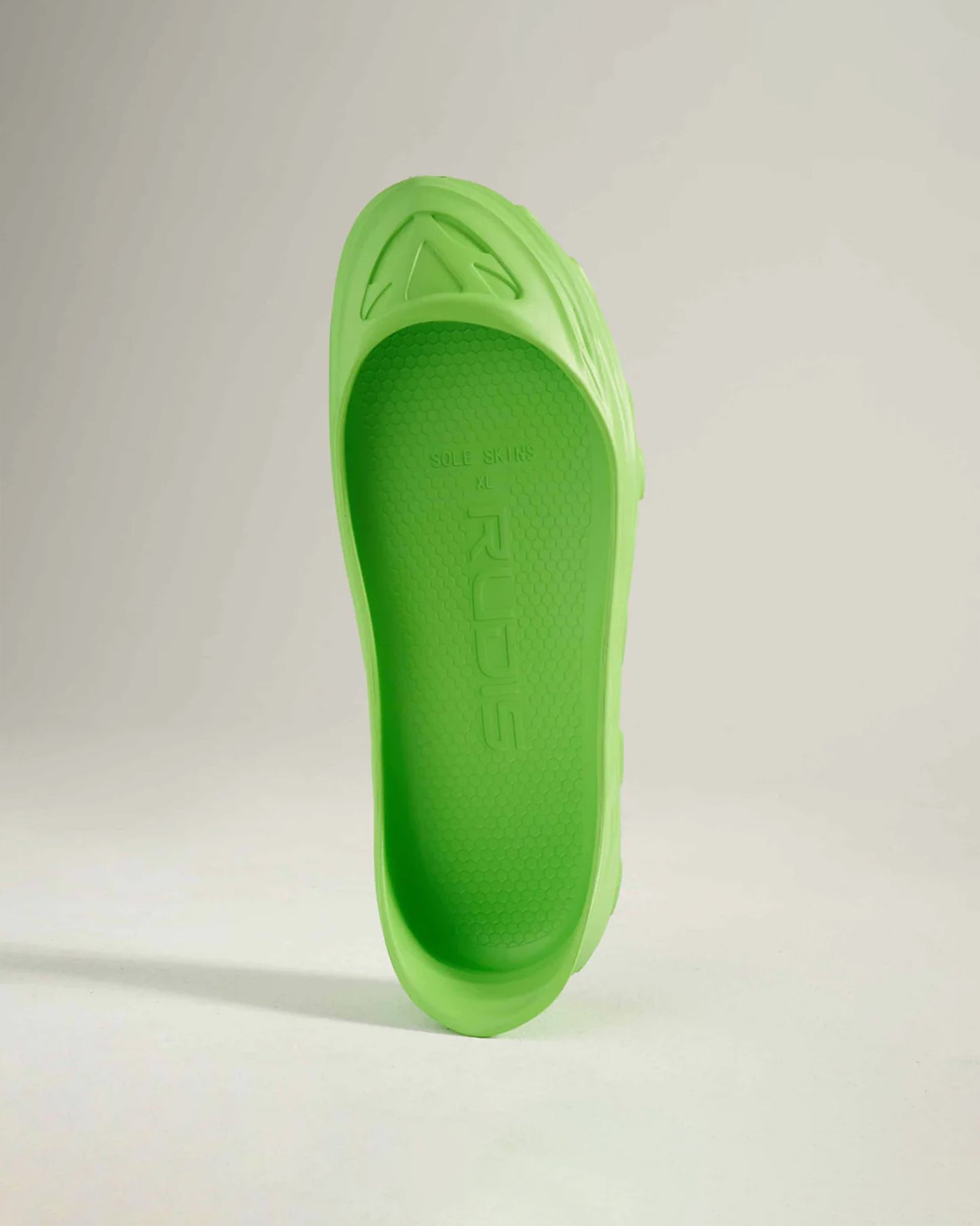 A vibrant green shoe sole that showcases a modern design with a textured surface and a distinct logo ideal for athletic footwear