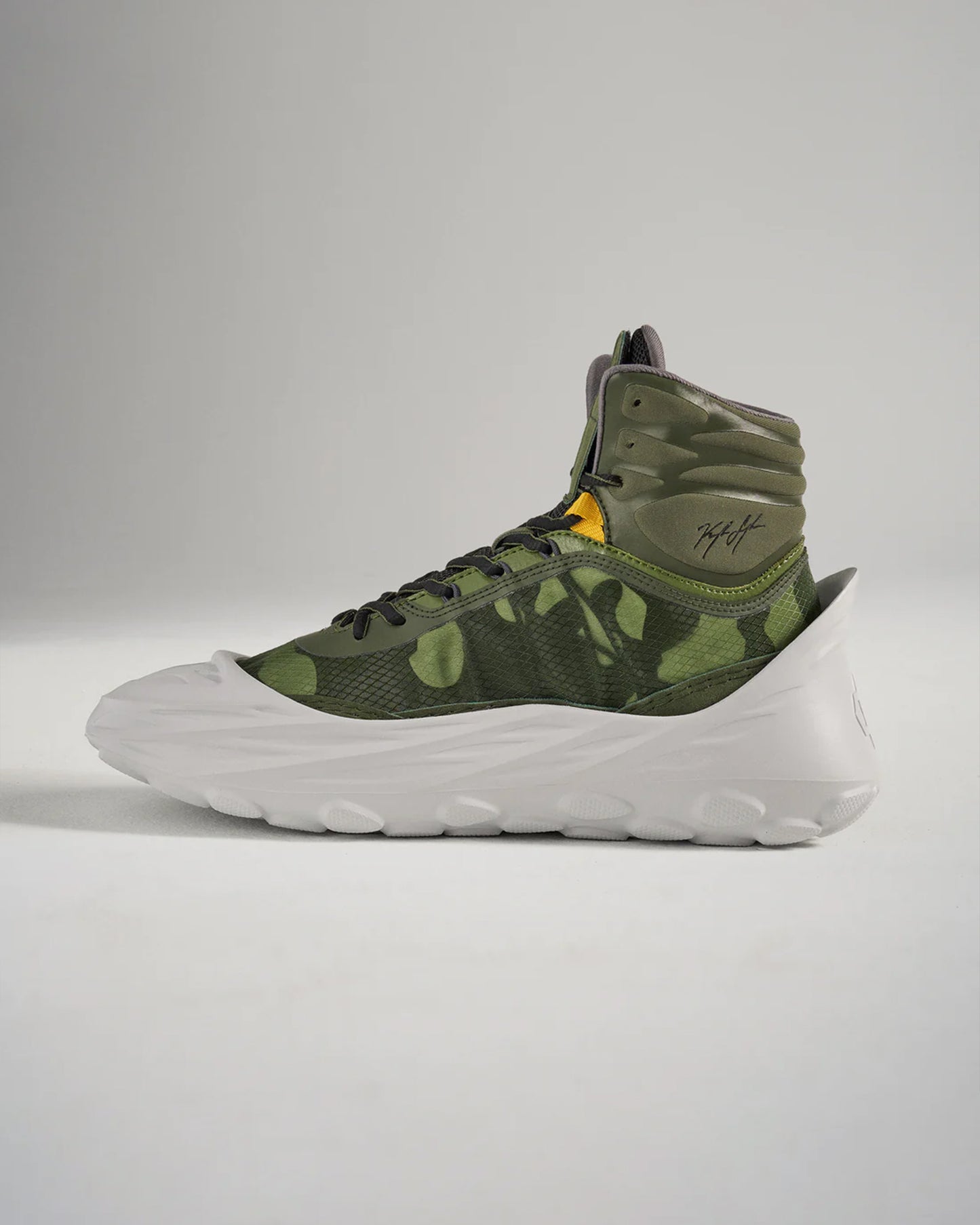 A high-top sneaker featuring a green camouflage design lightweight construction and a white modern sole blending style and functionality