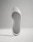 A minimalist white shoe with a sleek design and textured sole ideal for lightweight performance