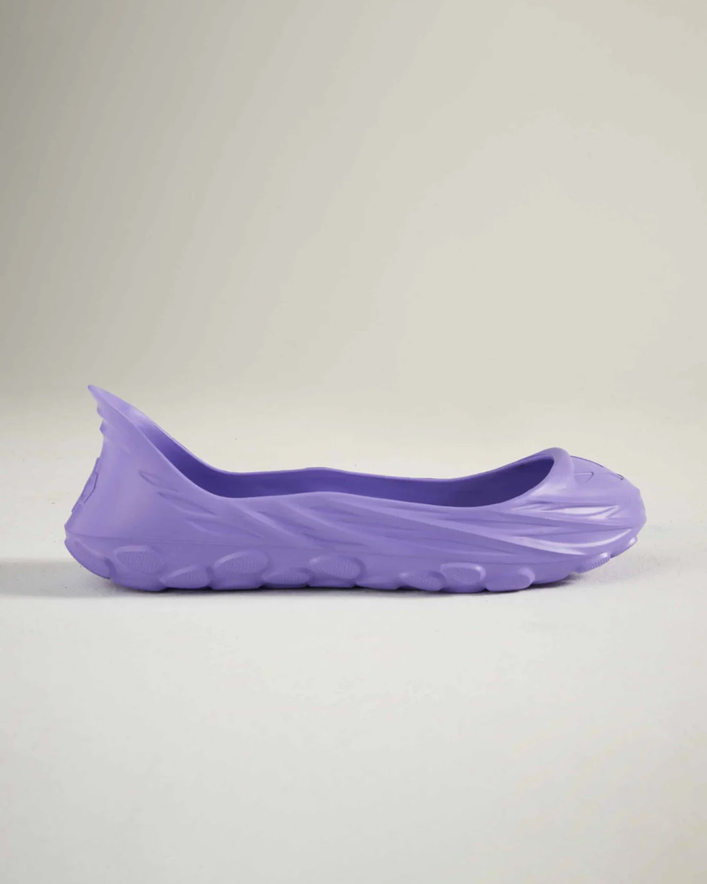 A side view of a sleek lightweight purple shoe designed for comfort and style featuring a smooth upper and textured sole