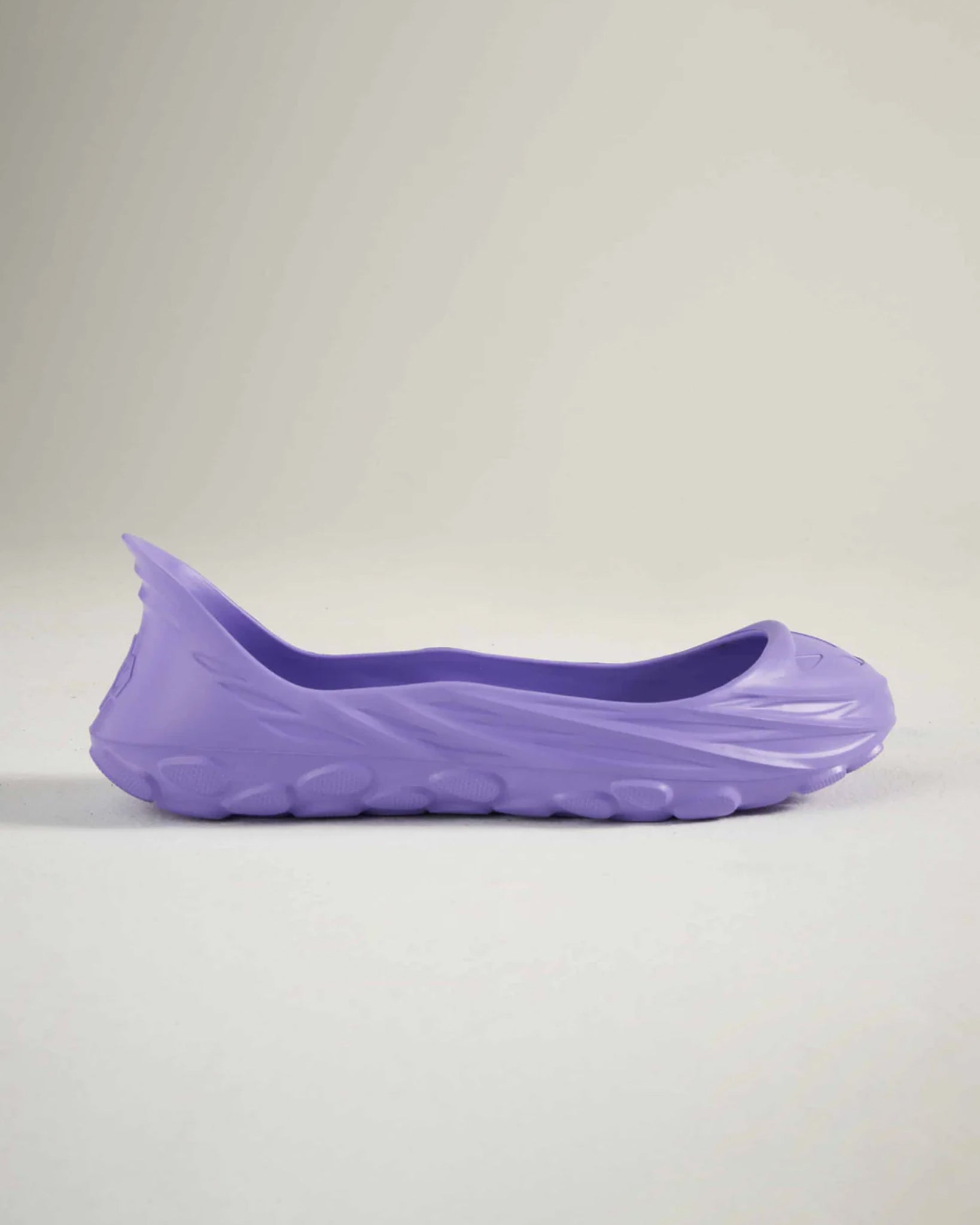 A side view of a sleek lightweight purple shoe designed for comfort and style featuring a smooth upper and textured sole