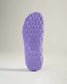 The image features a close-up view of a textured purple shoe sole highlighting its hexagonal pattern and unique design elements