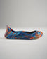 A vibrant and colorful pair of ballet flats showcasing an abstract design in blue orange and teal hues presented in a side view against a neutral background
