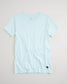 A light blue short-sleeved t-shirt displayed against a neutral background featuring a simple crew neckline and a subtle logo on the bottom left side