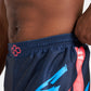 Close-up view of a mans waist wearing navy shorts with colorful graphic designs and an elastic waistband