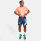 A cheerful young athlete wearing a vibrant orange t-shirt and navy blue shorts showcasing dynamic graphics and athletic shoes exuding energy and enthusiasm
