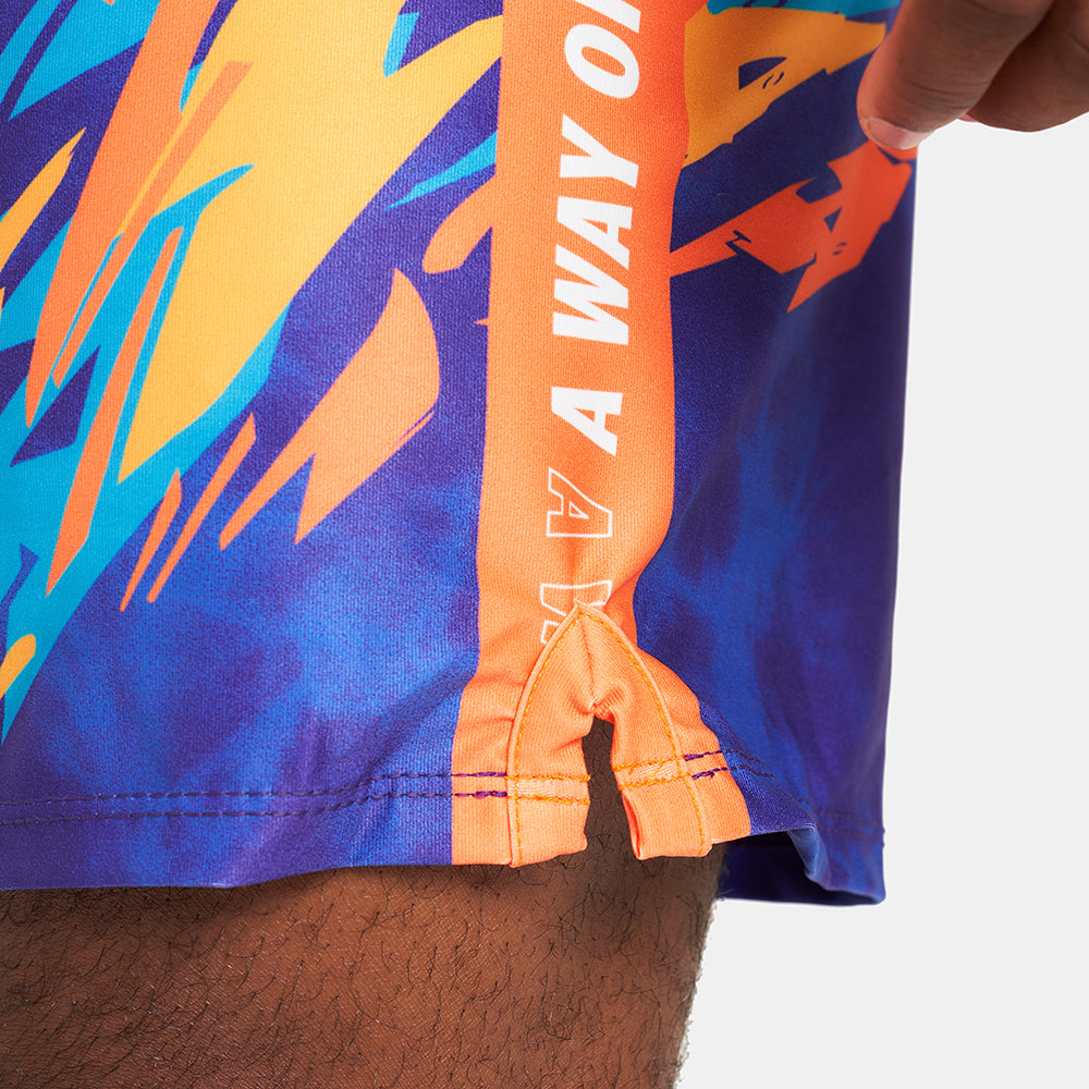 Colorful swim trunks featuring bold orange blue and yellow patterns with a side seam that reads A WAY OF