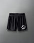 Black athletic shorts with a logo on a gray background