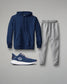 Navy hoodie, gray sweatpants, and blue athletic shoe on a gray background