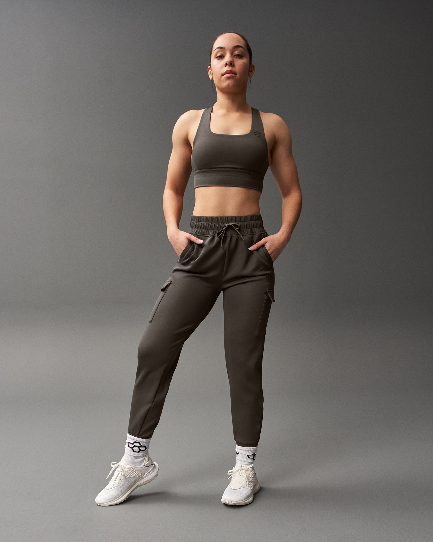 Woman wearing a brown athletic outfit on a gray background