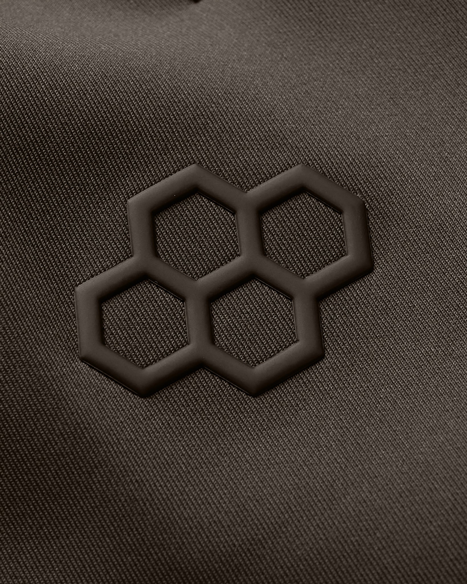Close-up of a textured surface with a black geometric pattern on a dark gray background