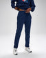 Person wearing a navy tracksuit with a logo on a white background