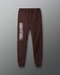 Brown sweatpants with 'Wrestling All In' text on a gray background