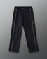 Front view of RUDIS Movement Podium Pants in black with white piping, elastic waistband, side pockets, and subtle RUDIS logo.