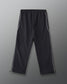 Back view of RUDIS Movement Podium Pants in black with white side piping, relaxed-leg silhouette, and adjustable ankle hems.